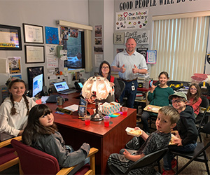 students at principal desk
