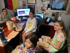 four students eating around the principal's desk