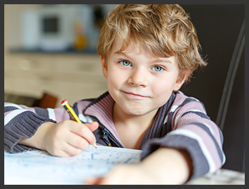 young boy with paper and pencil