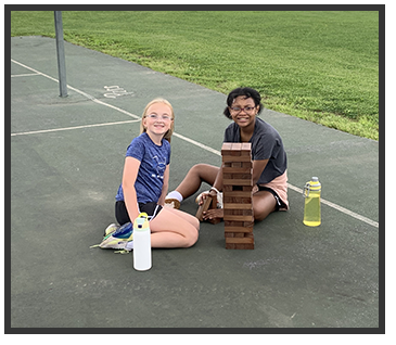 Two students stacking blocks on the playground