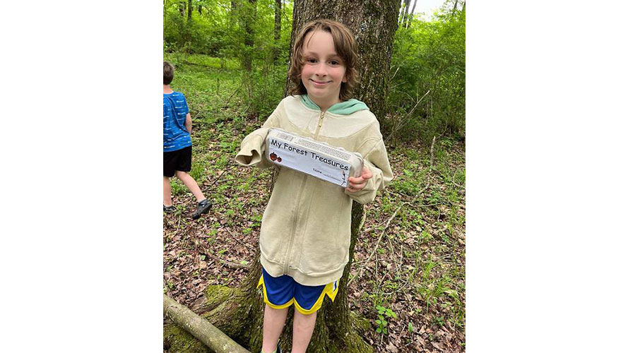 Student holding a box of forest treasures