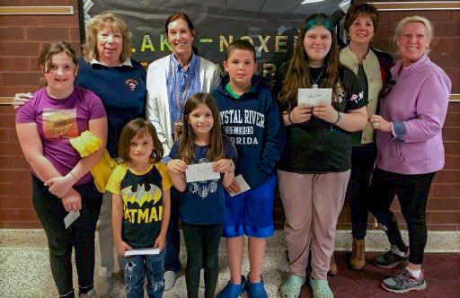 Most Improved students holding their awards with their teachers