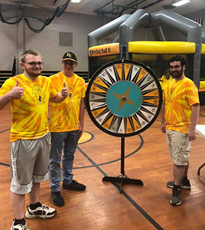 Students standing next to the activity spin wheel