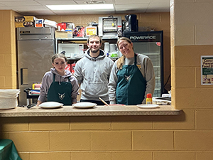 Three students at the local food bank helping with the pancake food drive