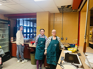 Three students helping in the kitchen