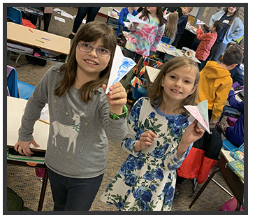 students holding their paper airplanes