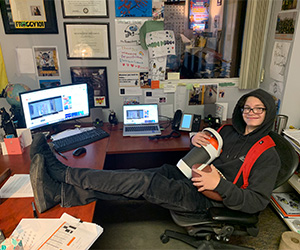 male student sitting at principal desk