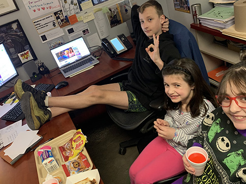 Three students sitting around the principal's desk