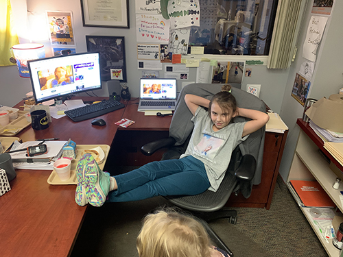 Girl in principal's chair enjoying Principal's Toast celebration