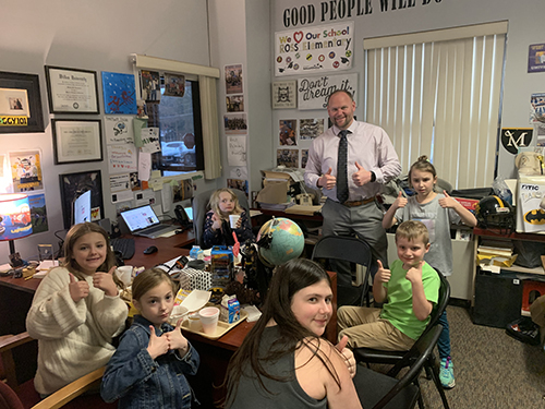 Principal honoring students in his office with Principal Toast