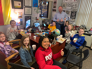 Students and principal in the principal's office during the Principal's Toast celebration