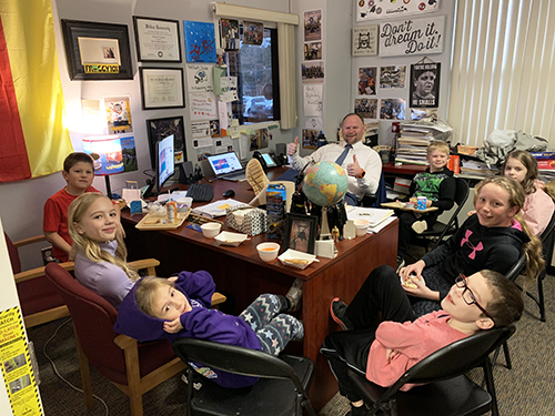 Group of happy students in the principal's office