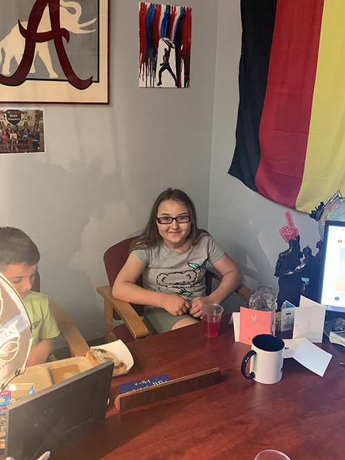 Two students sitting in front of principal's desk enjoying the Principal's Toast award