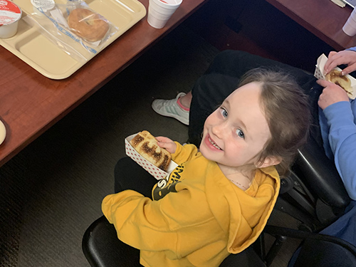 Little girl enjoying toast in the principal's office