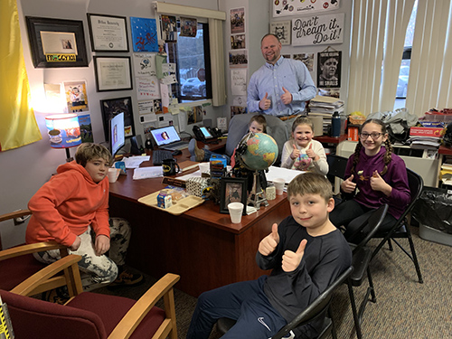 Group of happy students in the principal's office