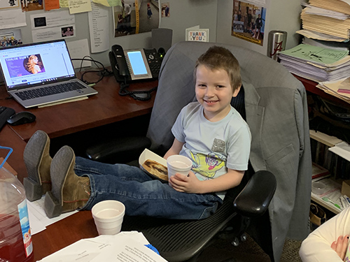Boy smiling in the principal's office enjoying toast
