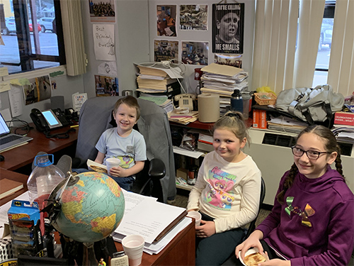 Group of happy students enjoying toast in the principal's office