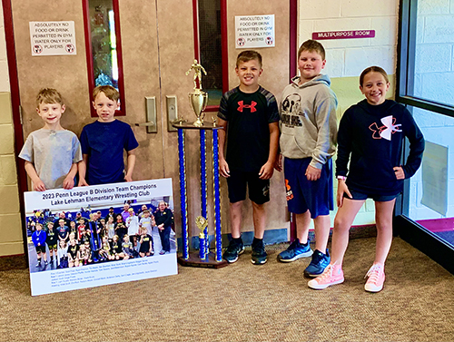 Lake Lehman Elementary wrestling team proudly standing next to huge trophy
