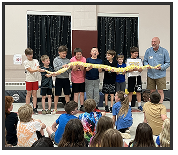 Adult and students holding a yellow snake