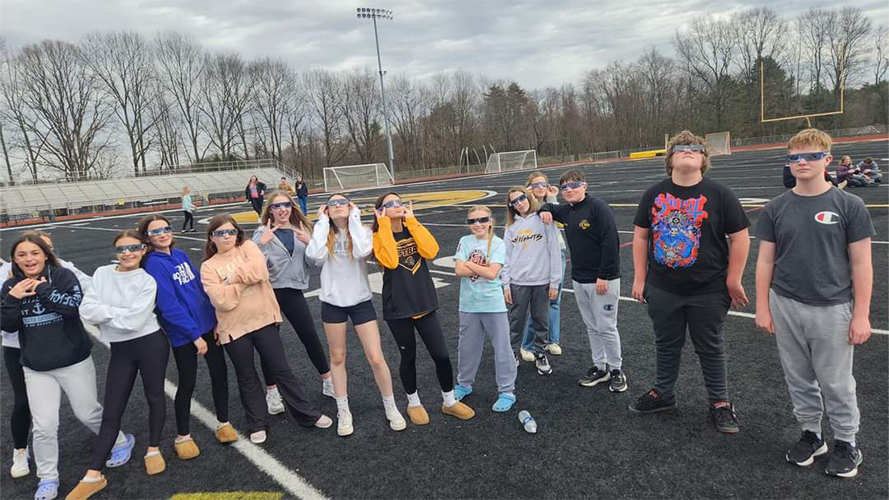 Group of students outside wearing solar eclipse protective glasses