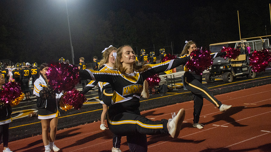 Cheer team on the football field in action