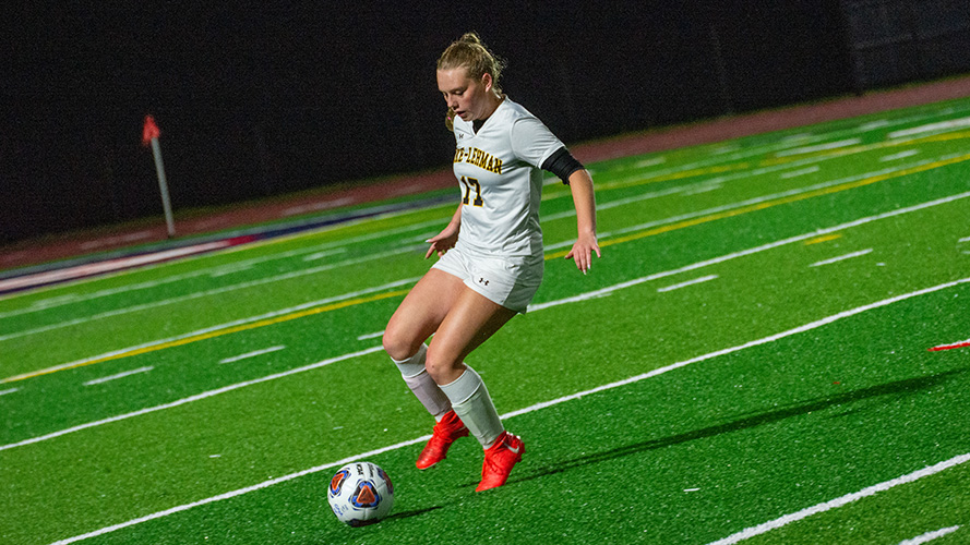 Female soccer player on the field getting ready to kick the ball